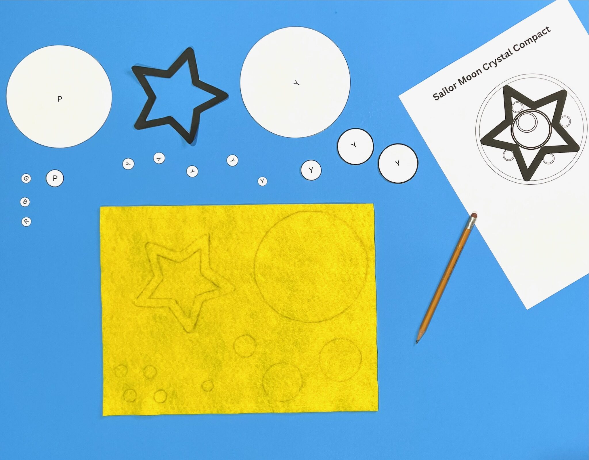 printable ornament pieces and shapes traced onto yellow felt sheet using pencil