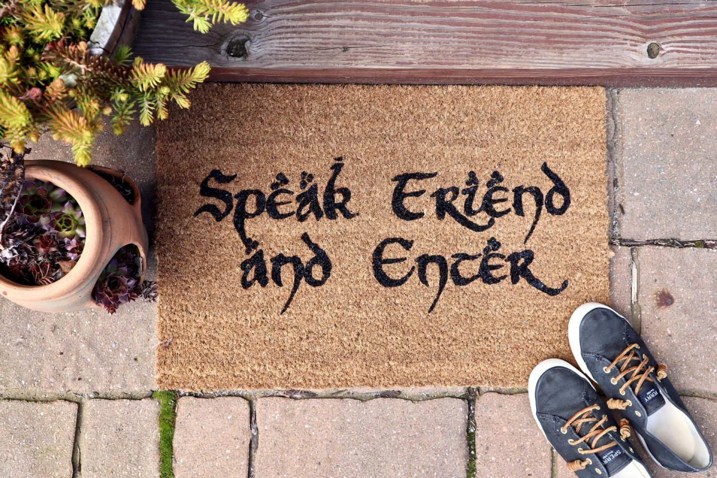 doormat reads 'speak friend and enter' with shoes and plants nearby
